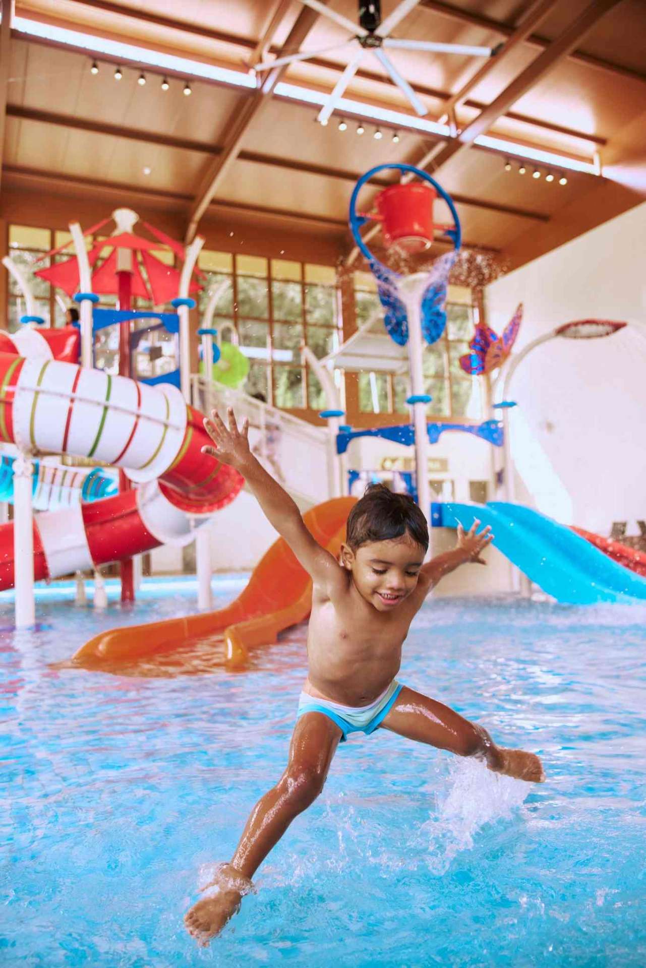 Criança pulando feliz na área kids